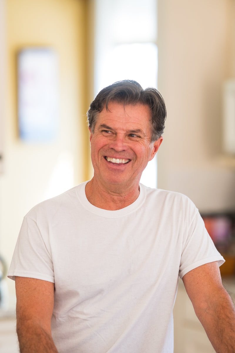 Image of Tim, owner of Tim's Serious Shake, wearing a white t-shirt in an indoor setting and smiling
