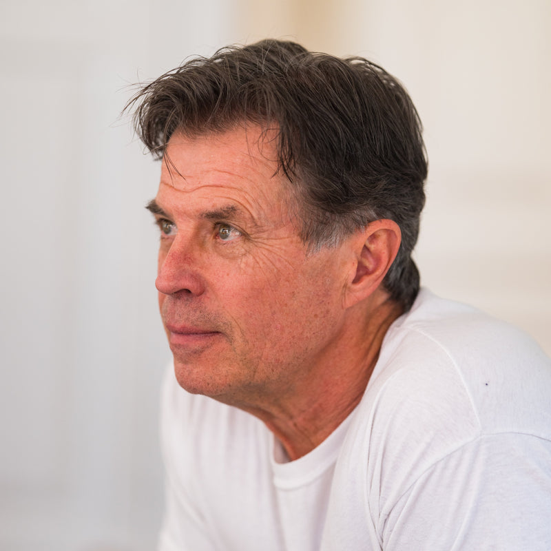Image of Tim, owner of Tim's Serious Shake, wearing a white t-shirt, looking very serious