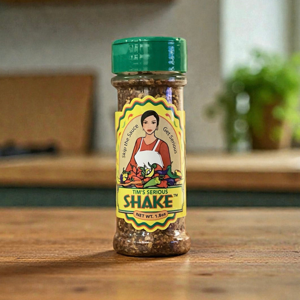 Single jar of Tim's Serious Shake premium all natural pepper seasoning shake on a wood surface with blurred background